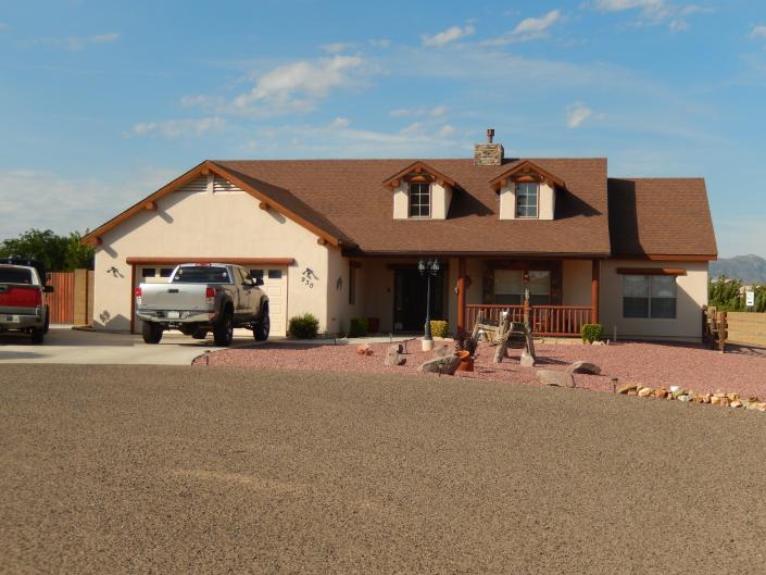 This gorgeous home features tan stucco accompanied with redwood trim for a rustic feel. 